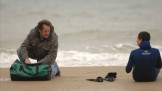 due persone sedute in riva al mare